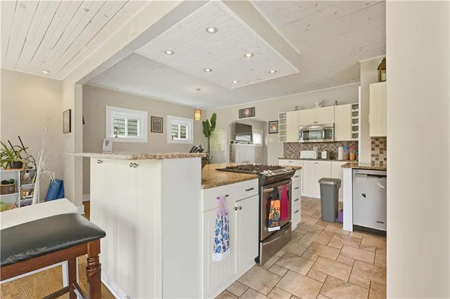 a kitchen with stainless steel appliances granite countertop a refrigerator and a stove top oven
