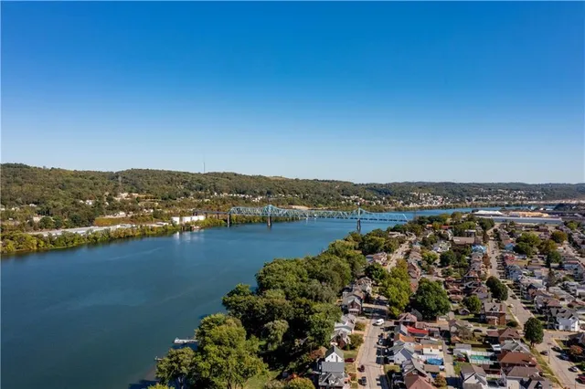 an aerial view of residential houses with outdoor space and river