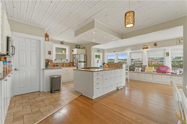 a large white kitchen with wooden floors and glass doors