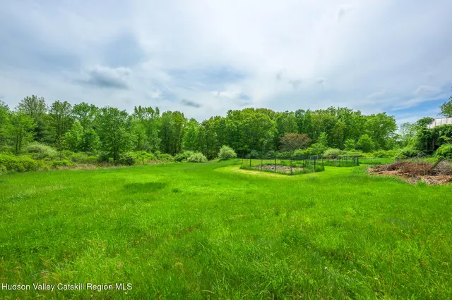 a view of a green field with wooden fence