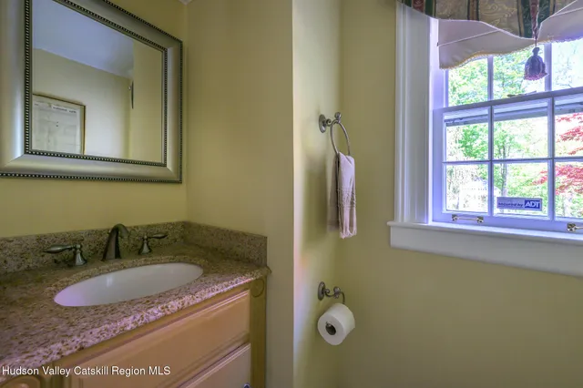 a bathroom with a granite countertop sink and a mirror