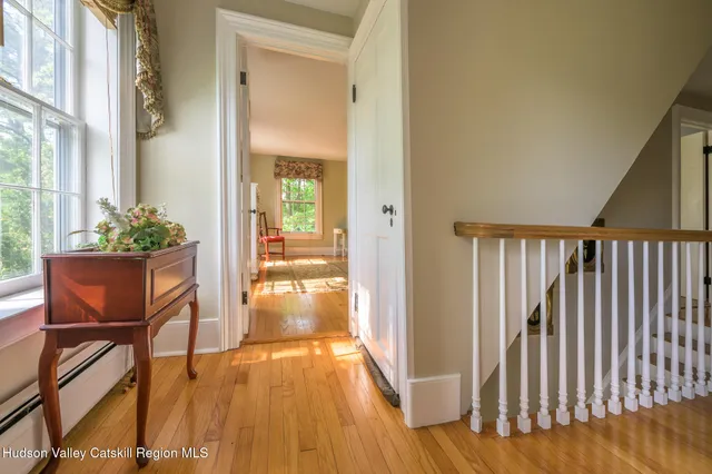 a view of a hallway with wooden floor and furniture