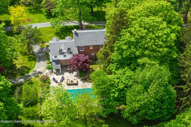 an aerial view of a house with a yard swimming pool and outdoor seating