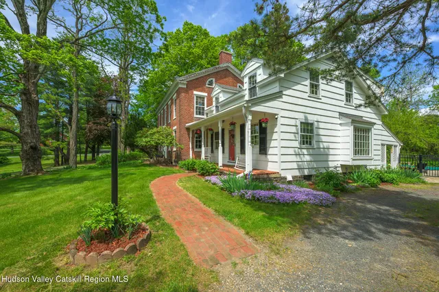 a front view of a house with a yard and trees