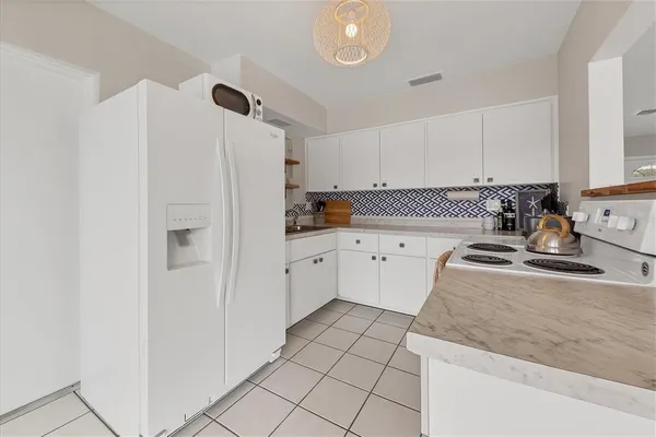 a kitchen with white cabinets and sink