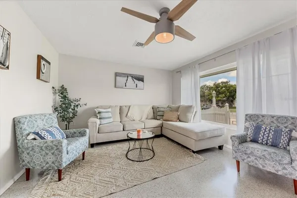 a living room with furniture and a view of kitchen
