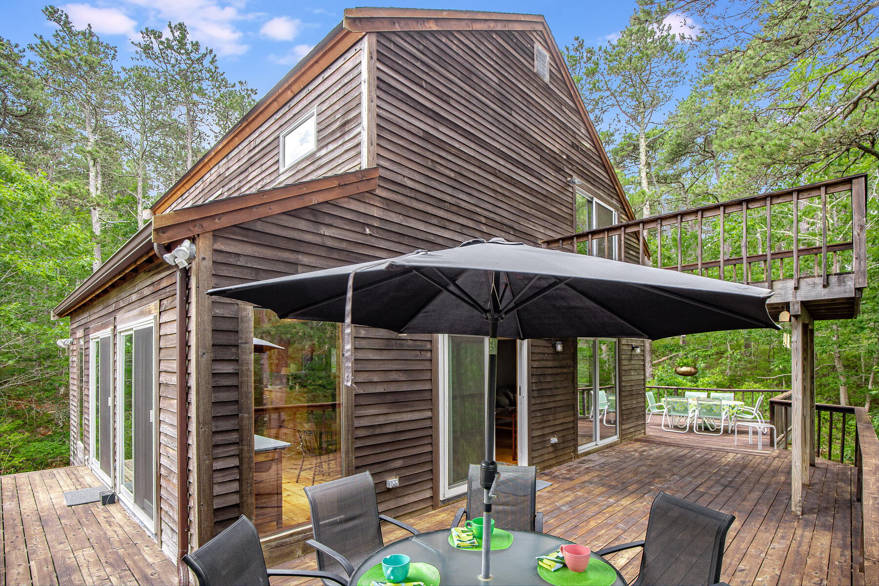20 Pine Valley Road Wellfleet, MA 02667 - Photo 25 of 52 a backyard of a house with table and chairs under an umbrella