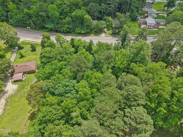 an aerial view of residential house with outdoor space and trees all around