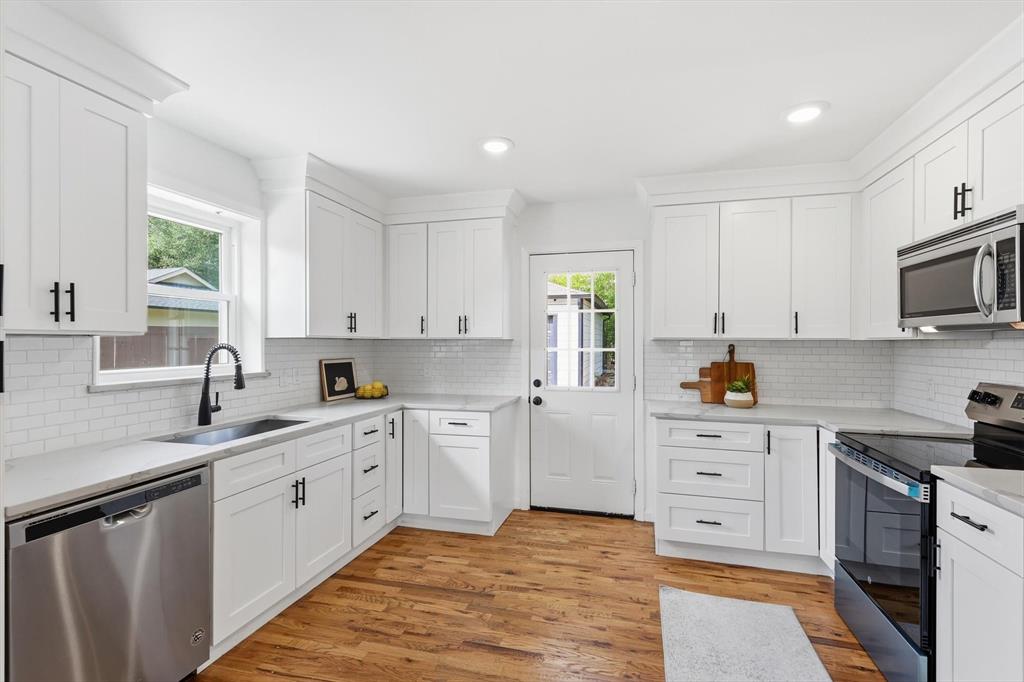 6811 Patrick Drive Dallas, TX 75214 - Photo 19 of 40 Kitchen with appliances with stainless steel finishes, white cabinetry, light wood finished floors, tasteful backsplash, and recessed lighting