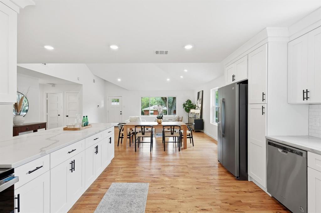 6811 Patrick Drive Dallas, TX 75214 - Photo 20 of 40 Kitchen featuring white cabinetry, appliances with stainless steel finishes, recessed lighting, light wood-style flooring, and decorative backsplash