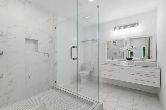 a bathroom with a shower a sink and a mirror
