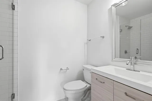 a bathroom with a granite countertop toilet a sink and a mirror