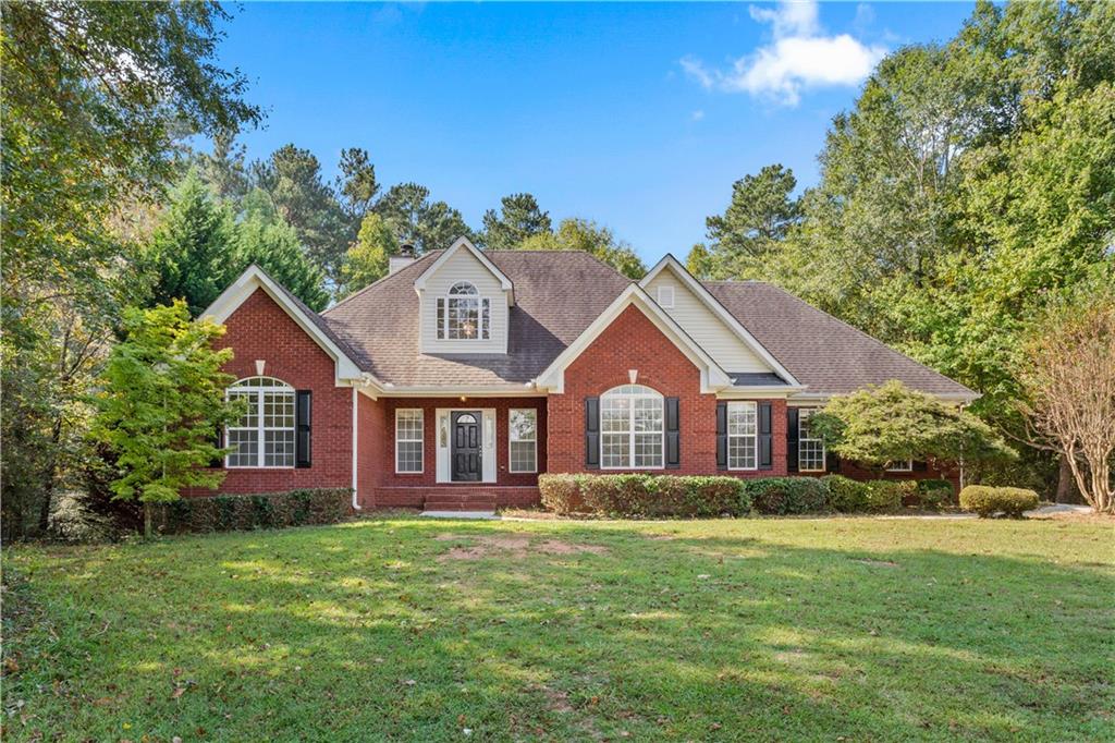 721 Tanner Road Dacula, GA 30019 - Photo 1 of 1 a front view of a house with a garden and trees