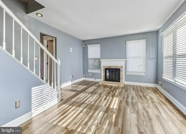 a view of a livingroom with wooden floor and fireplace