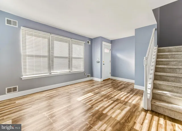 a view of a bedroom with wooden floor and windows