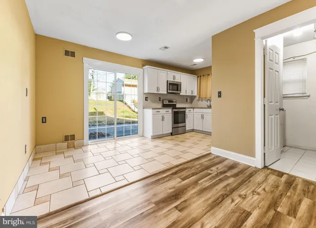 a large kitchen with a stove a refrigerator a sink dishwasher and wooden cabinets with wooden floor