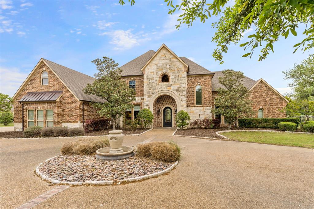 a front view of a house with garden and trees