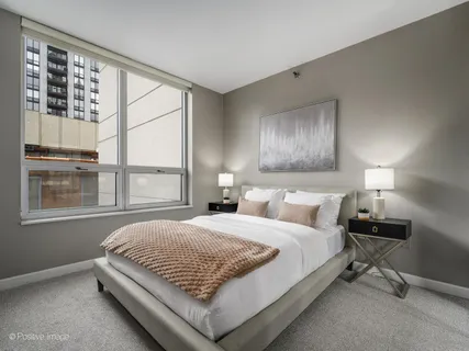 a bedroom with a bed lamp and window