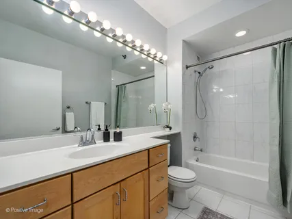 a bathroom with a double vanity sink toilet and shower