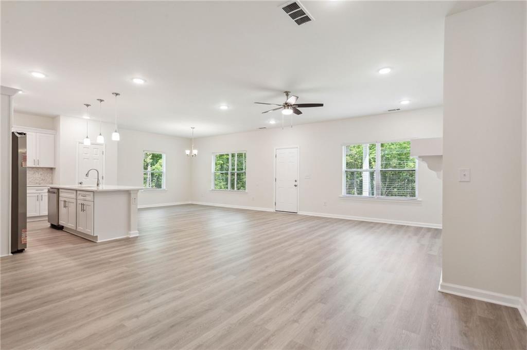 425 Boynton Road Hampton, GA 30228 - Photo 15 of 53 an empty room with wooden floor fan and windows