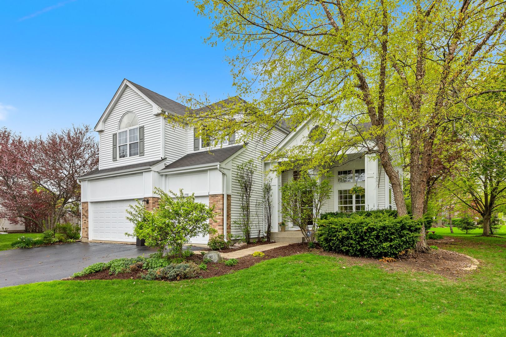7781 Rippling Ridge Court Gurnee, IL 60031 - Photo 2 of 31 a front view of a house with a yard and trees