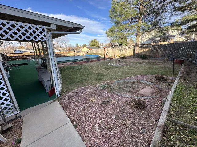 a view of a house with backyard and trees