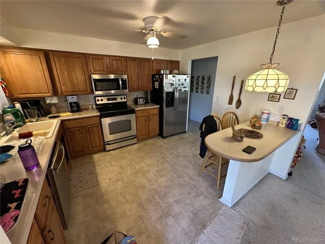 a kitchen with kitchen island a stove a sink and a refrigerator