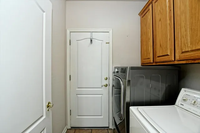 an empty room with windows and chandelier fan