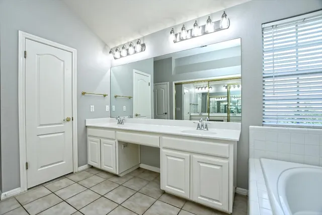 a bathroom with a bathtub a sink and a mirror