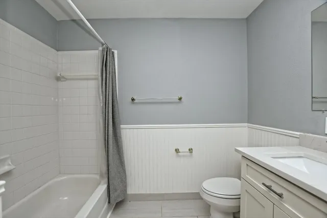a bathroom with a granite countertop sink a toilet and a mirror