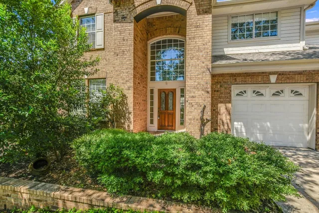 front view of a brick house with a small yard