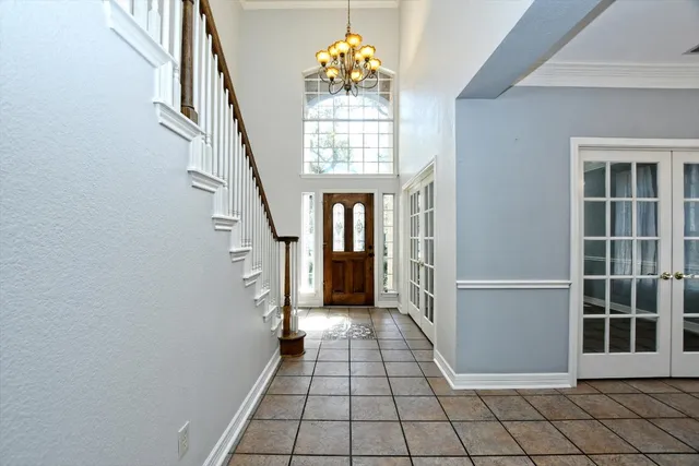 an empty room with windows a fireplace a ceiling fan and wooden floor