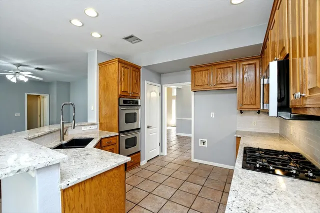 a kitchen with stainless steel appliances granite countertop a stove a sink and a microwave