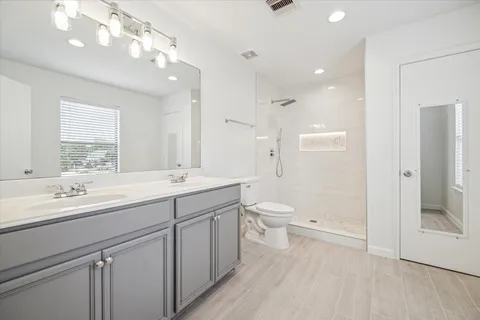 a bathroom with a sink a toilet and shower
