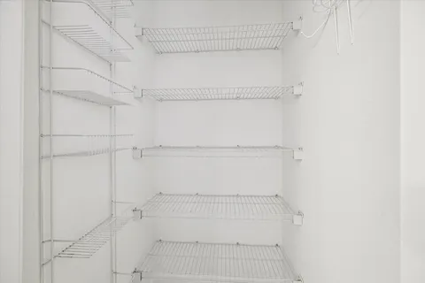 a view of walk in closet with empty racks