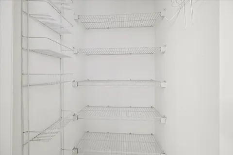 a view of walk in closet with empty racks