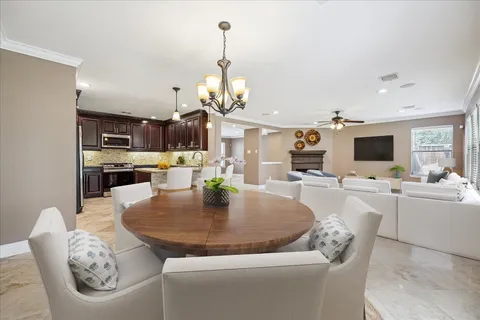 a living room with furniture kitchen view and a chandelier
