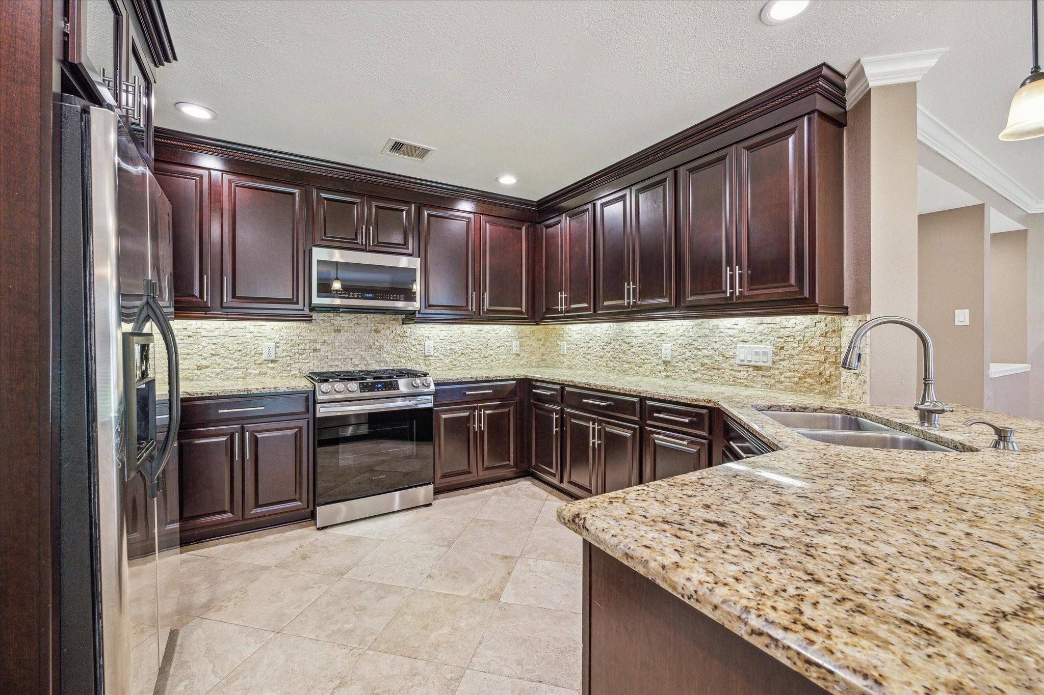2950 Valiant Scene Court Houston, TX 77038 - Photo 7 of 21 a kitchen with a stove a sink and a microwave