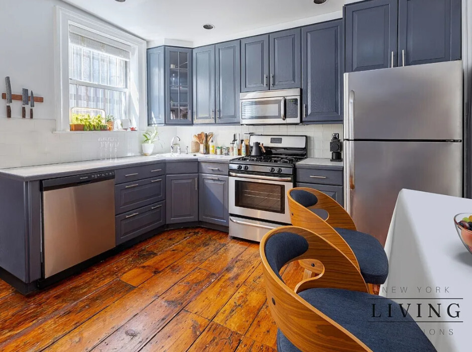 265 West 30th Street Manhattan, NY 10001 - Photo 11 of 20 a kitchen with stainless steel appliances granite countertop a refrigerator a stove top oven a sink dishwasher and white cabinets with wooden floor