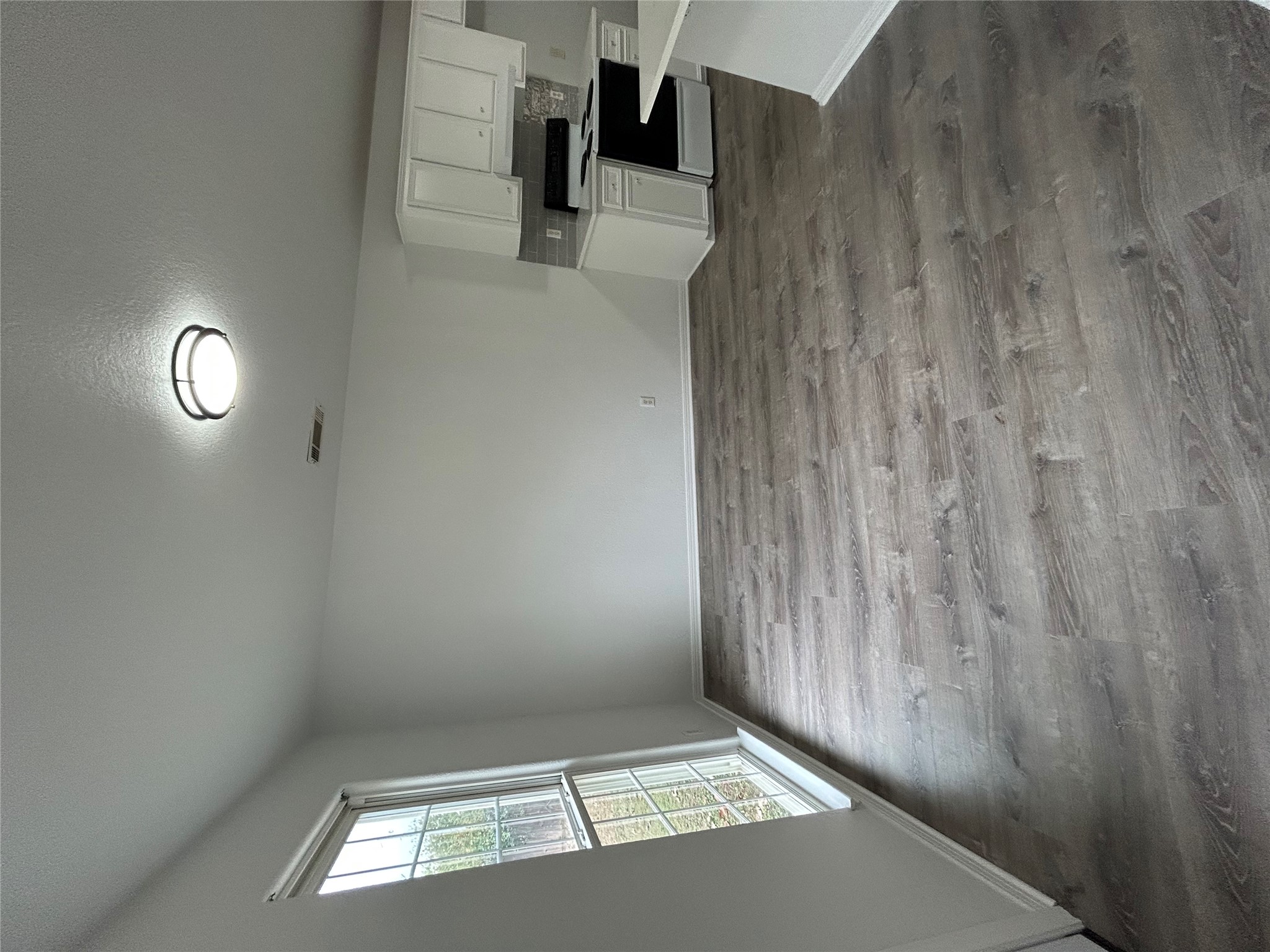 203 Maynard Street Bastrop, TX 78602 - Photo 13 of 27 wooden floor in an empty room with a window