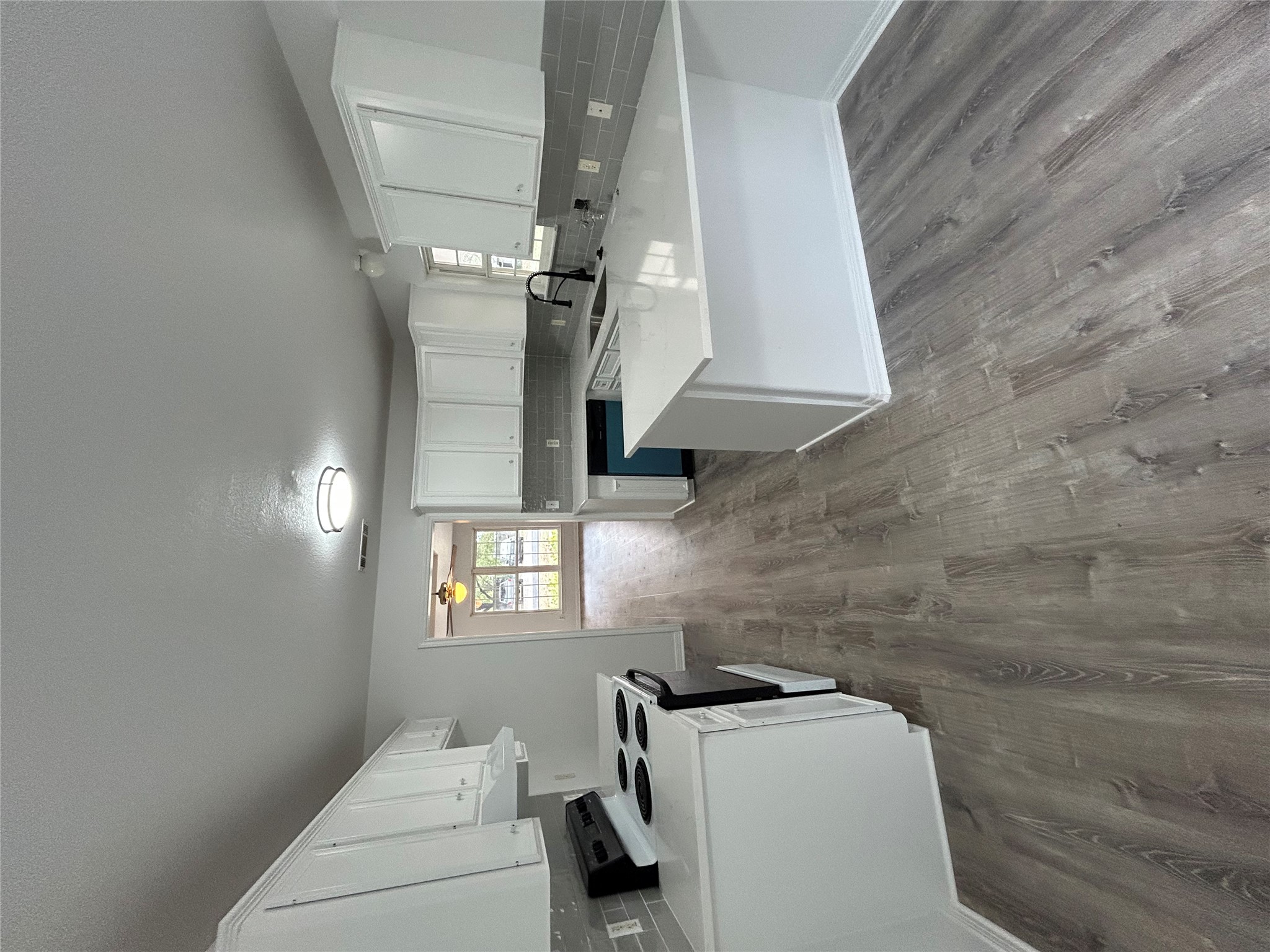 203 Maynard Street Bastrop, TX 78602 - Photo 9 of 27 a kitchen with stainless steel appliances granite countertop a sink dishwasher stove and white cabinets with wooden floor