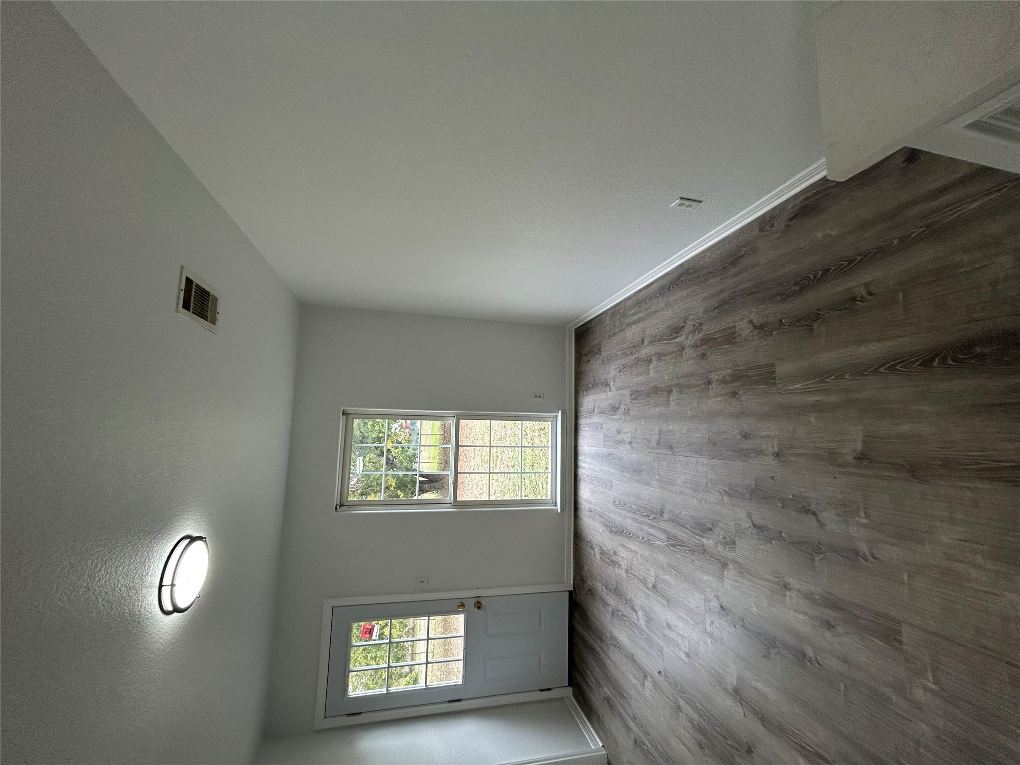 203 Maynard Street Bastrop, TX 78602 - Photo 10 of 27 an empty room with wooden floor and windows