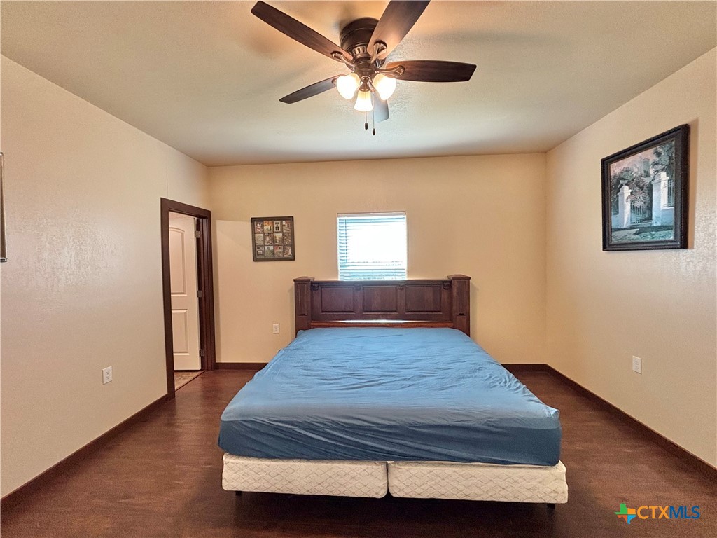 174 Riley Lane Port O'Connor, TX 77982 - Photo 34 of 47 a bedroom with a bed and a chandelier
