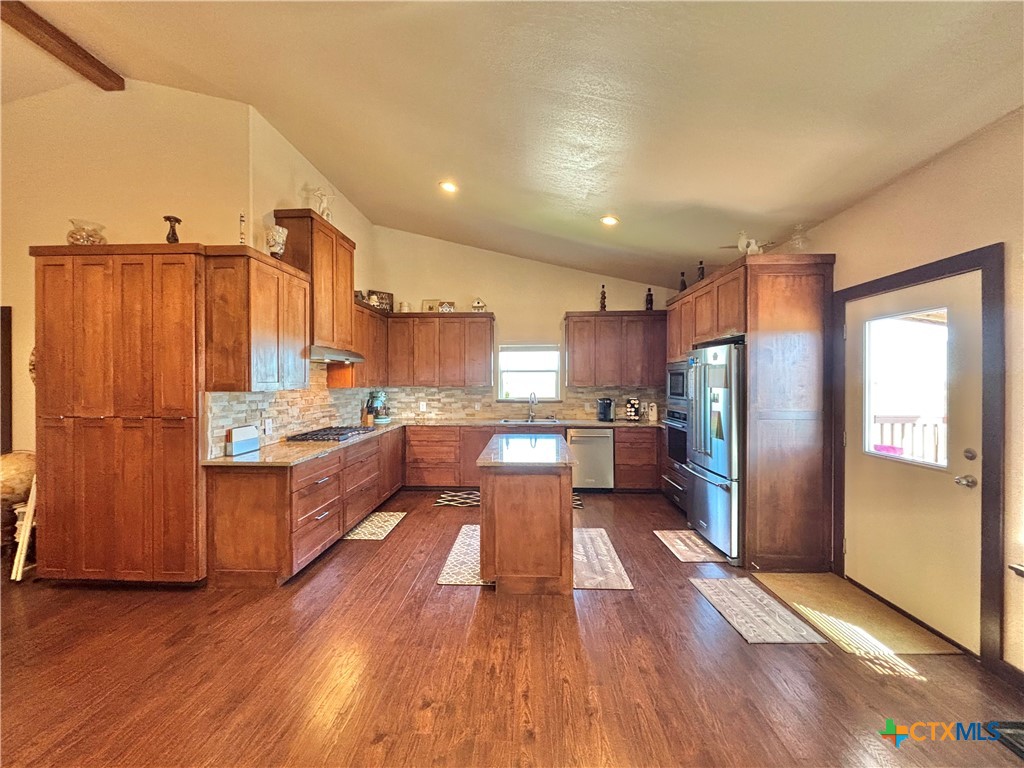 174 Riley Lane Port O'Connor, TX 77982 - Photo 6 of 47 a large kitchen with a large counter top space a sink stainless steel appliances and cabinets