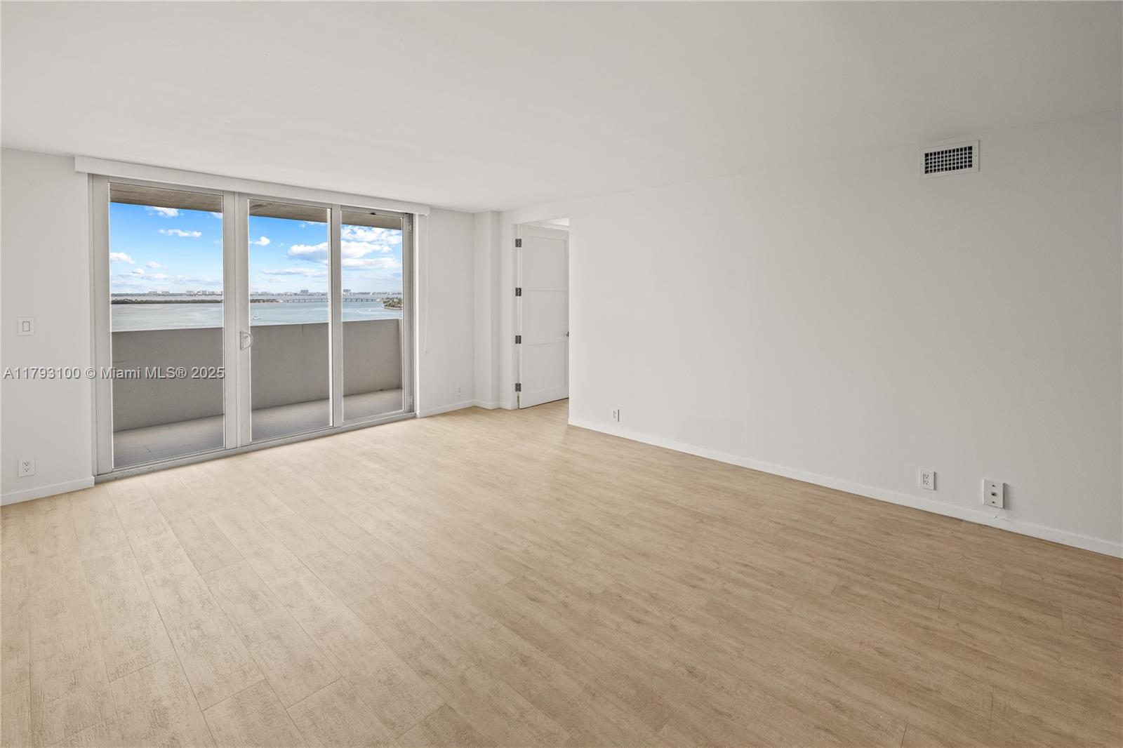 5 Island Avenue, Unit 15A Miami Beach, FL 33139 - Photo 3 of 19 a view of an empty room with wooden floor and a window