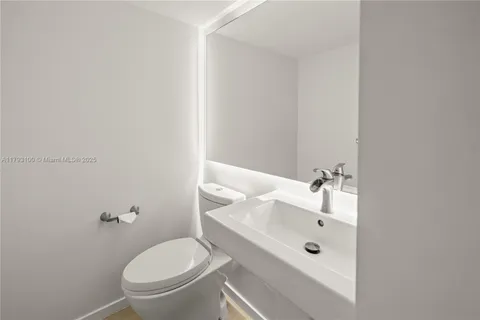 a bathroom with a granite countertop toilet and a sink