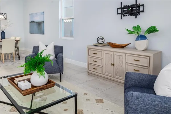 a living room with furniture a flat screen tv and kitchen view