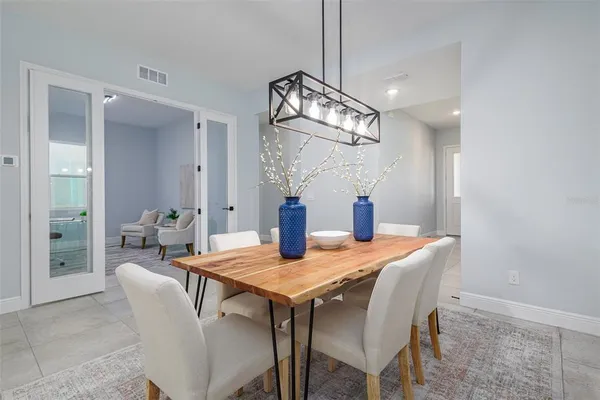 a kitchen that has a lot of white cabinets and stainless steel appliances