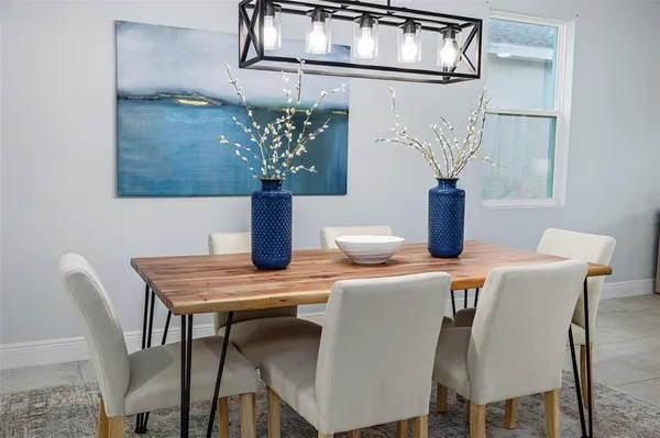 a view of kitchen island a sink wooden floor and chairs