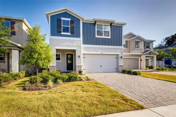 a view of yellow house with swimming pool in front of it